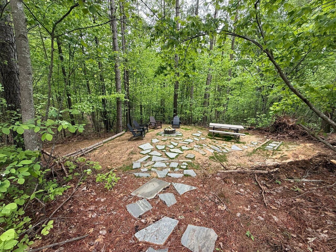 Wooded campsite with a fire pit and picnic table at Sasquatch Farm RV Park