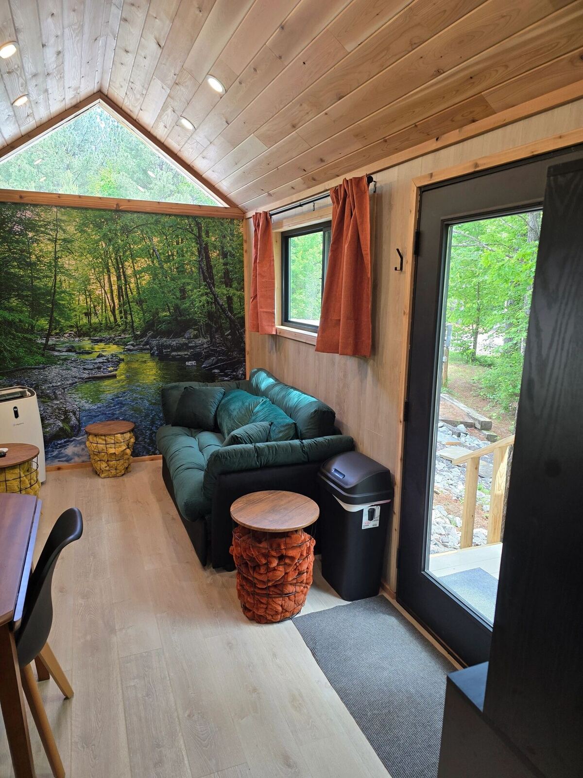 Living room seating area with forest mural at Cabin @28