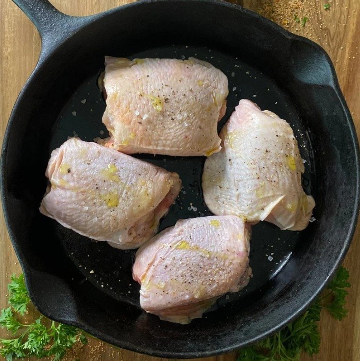 Tennessee Grass Fed chicken thighs in a cast iron skillet