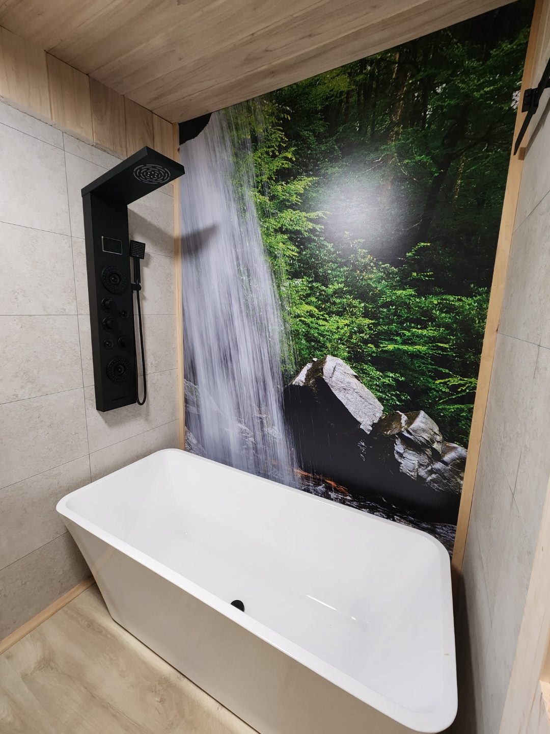 Soaking tub beneath a hand-painted waterfall mural at the Spa King Cabin