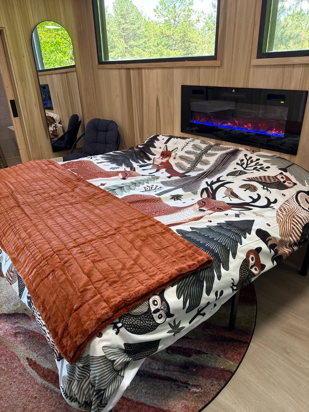 King bed with a built-in electric fireplace at the Spa King Cabin